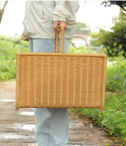 A stylish hand-woven imitation rattan storage basket for magazines shown outdoors