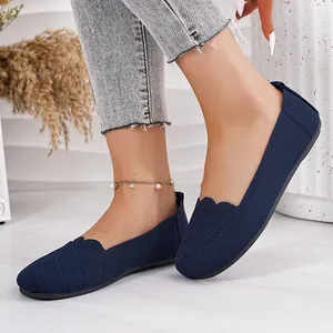 Close-up view of navy blue flyknit round toe flat shoes with delicate scalloped edges