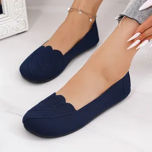 Close-up of navy blue breathable knit flat shoes with unique scalloped edge design