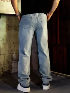Macro view of light blue straight-leg denim jeans featuring side bead and rhinestone details