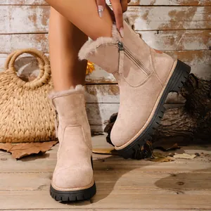 Dettaglio stivali da neve in camoscio beige con fodera in pelliccia e zip laterale.