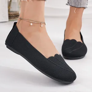Detail of breathable fly-woven fabric and scalloped edge on black ballet flats.