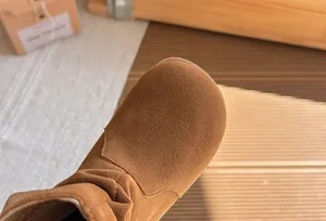 Gros plan du bout rond en daim marron sur les bottines plissées vintage de style Maillard pour filles