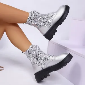 Dettaglio degli stivaletti con zeppa in paillettes argento e suola spessa nera