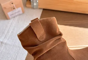 Gros plan sur les bottines en daim marron pour filles avec plis rétro style Maillard