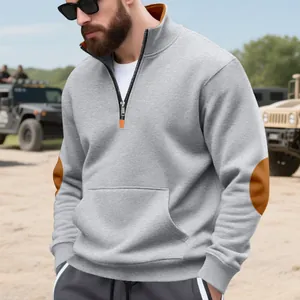 Detailweergave van een grijze herensweatshirt met bruine decoratieve elleboogstukken.
