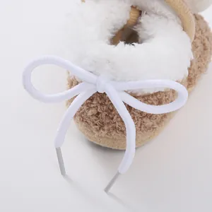 Detailed macro shot of baby sherpa booties with white plush trim and decorative bow lace
