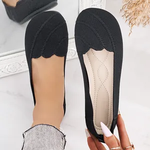 Close-up of black breathable fly-knit flats with scalloped edge detail