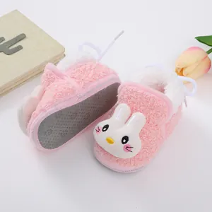 Close-up detail of soft pink baby fleece booties featuring a cute white cartoon rabbit design