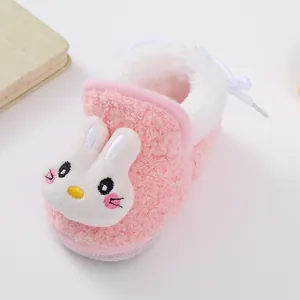 Close-up detail of soft pink plush baby winter boots with a cute white bunny face design
