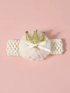Detailed view of baby headband with golden glitter crown and lace bow decoration