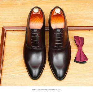 Top-down detail of dark brown leather oxford shoes with wooden shoe trees and bow tie.