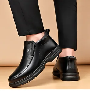 Détail de vue latérale de bottes d'hiver en cuir noir pour hommes à semelle épaisse.