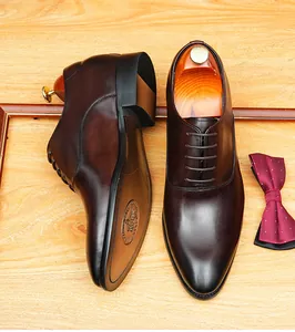 Premium dark brown leather oxford shoes for business formal wear with an elegant bowtie.