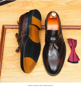 Men's leather tassel loafers featuring brogue wingtip details and burnished finish.