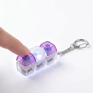 Close-up of a 3-key mechanical switch fidget toy keychain with LED light-up effect