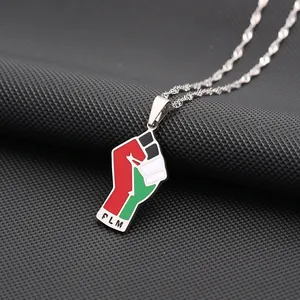 Detail van roestvrijstalen vuist hanger met Palestijnse vlagkleuren en PLM-tekst.