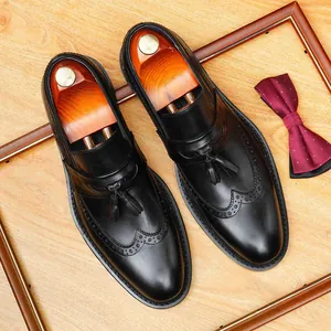 Classic black leather tassel loafers with wingtip brogue detailing for business casual wear