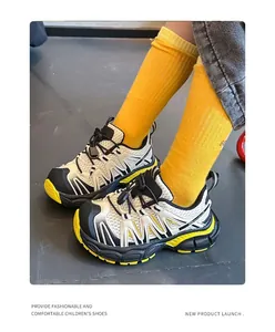 Detailed view of breathable white and black children's sneakers with yellow accents