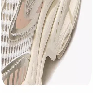Close-up detail van ademend mesh en dikke zool op beige dad-schoenen voor kinderen.