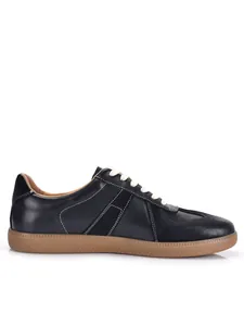 Close-up of black leather German Army Trainers with gum sole and white stitching