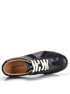 Detailed close-up view of black leather retro GAT sneaker with white laces and gum sole