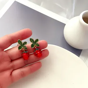 Detaillierte Ansicht von handgefertigten Beeren-Emaillenohrringen mit grünen Blättern