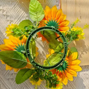 Detailed back view showing the green plastic base of an artificial sunflower candle ring