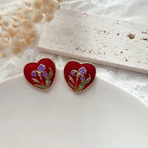 Dettaglio orecchini vintage a cuore con fiori di iris e finitura in smalto rosso