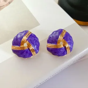 Macro detailed shot of vintage purple enamel gold earrings with twisted design