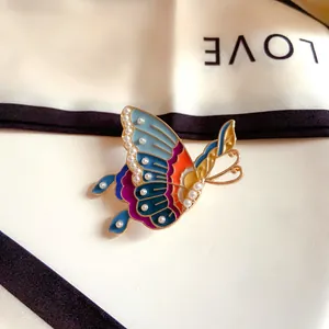 Detailed view of a vintage colorful enamel butterfly brooch with elegant pearl accents