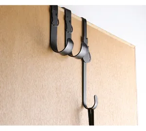 Close-up detail of creative black metal cat silhouette over-the-door hook on wood