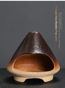 Close-up of a ceramic triangle palo santo burner with a rustic mini fireplace design