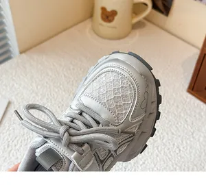 Gros plan de baskets argentées en maille respirante pour filles avec motif cœur