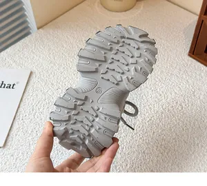 Gros plan sur la semelle extérieure antidérapante d'une basket chunky grise pour fille.