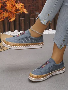Vista detallada de mocasines azules con entresuela de corcho y costuras blancas decorativas