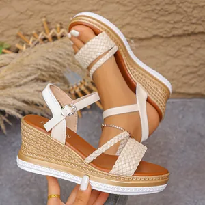 Détail de sandales compensées beige avec brides tressées et semelle plateforme