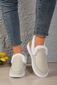 Close-up of beige suede-like slip-on shoes with soft white faux fur lining and trim