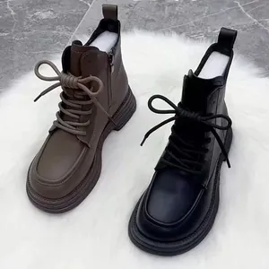 Close-up of black and brown British style Martin boots with thick soles and laces