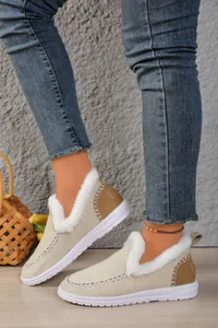 Detail of women's warm beige snow boots with white faux fur lining and durable sole