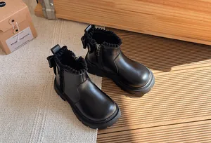 Close-up detail of black girl's Martin boots featuring bow back and warm fleece lining