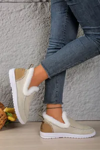Close-up of women's beige faux fur lined slip-on snow boots with white stitching.