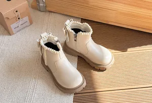 Elegant cream white girls' British style boots featuring pearl and bow details on floor