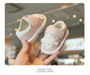 Dettaglio scarpe neonato rosa con pecora cartone animato e suola morbida