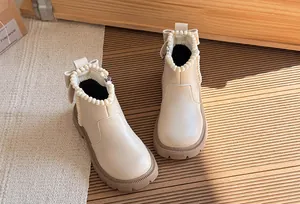 Detailed view of cream beige girls Martin boots with elegant pearl trim and bow decoration