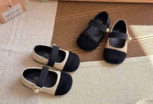 Close-up detail of stylish kids' French-style Mary Jane shoes in black and beige leather