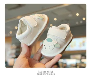 Dettaglio scarpe primi passi crema con pecorella cartoon e chiusura a strappo
