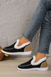 Detail view of women's slip-on fleece-lined winter boots on model wearing denim jeans.