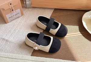 Detailed top view of bicolor girls Mary Jane shoes featuring a pearl and elastic strap