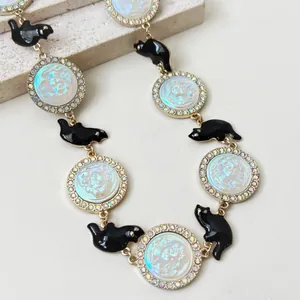 Detail of relief female portrait necklace with black animal charms and rhinestones.